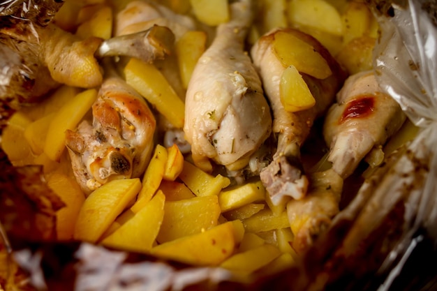 Un lapin diététique fait maison cuit avec des pommes de terre en gros plan dans un plat allant au four sur une table