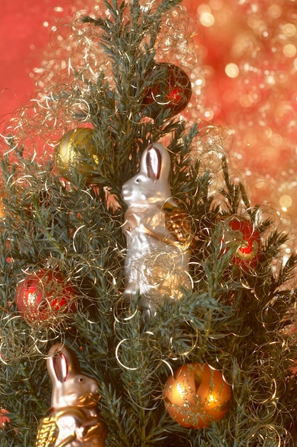 Photo le lapin de pâques assis dans l'arbre de noël