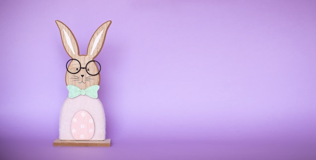 Lapin de Pâques en bois mignon sur une surface violette