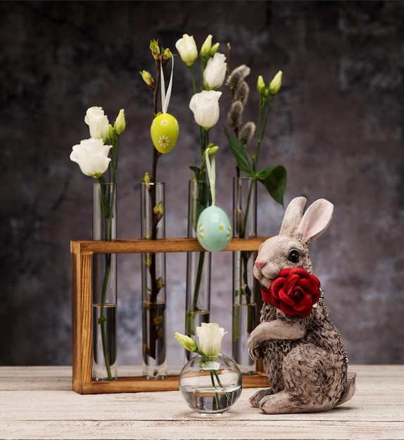 Lapin de Pâques et fleurs de printemps dans des vases en verre. Carte de voeux de Pâques
