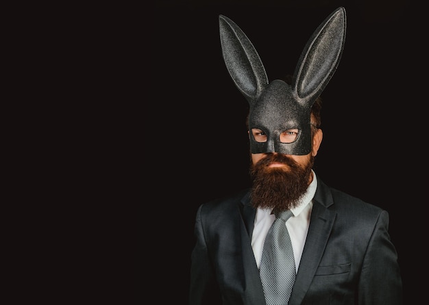 Lapin de Pâques. Homme lapin en colère brutal avec des oreilles de lapin sur fond noir.