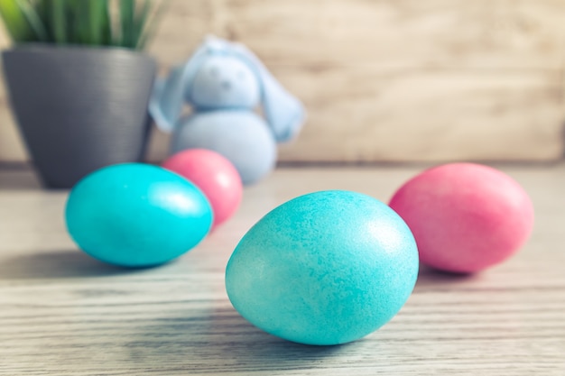 Lapin de Pâques jouet et oeufs peints sur une table en bois. Décorations de Pâques, symbole de vacances. Mise au point sélective au premier plan.