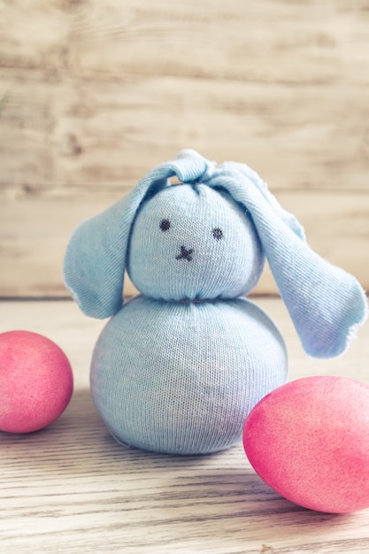 Lapin de Pâques jouet et oeufs peints sur une table en bois. Décorations de Pâques, symbole de vacances.