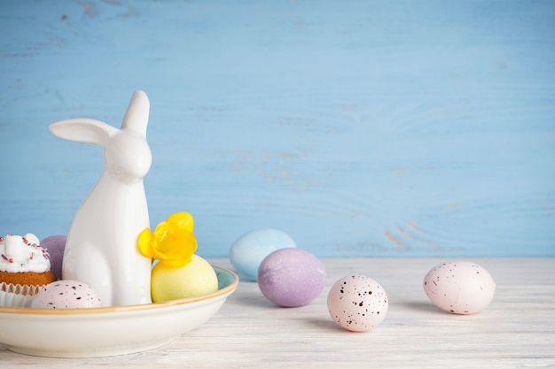 Lapin de Pâques et oeufs avec fleur sur fond de bois