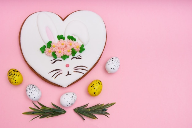 Lapin de Pâques, pain d'épice avec glaçage aux oeufs de caille sur table rose Espace copie