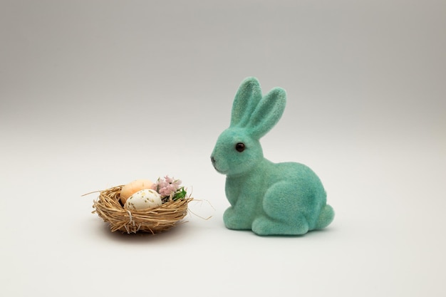 Lapin de Pâques par les oeufs de Pâques sur fond blanc