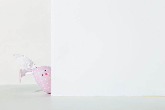 Lapin rose fait à la main, sur un blanc, le concept de lapin de Pâques.