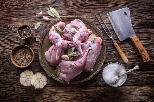 Photo lapin tranches de lapin crues avec des épices ail ustensiles de cuisine fourchette et boucherie cuisine de chasse