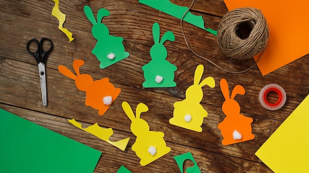 Lapins de Pâques en papier sur une surface en bois