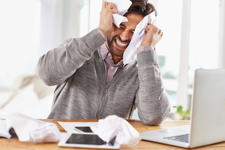 Photo laptop homme et frustré au travail avec du papier sur le bureau des heures supplémentaires et le stress pour respecter la date limite de démarrage du bureau et des documents pour la recherche sur l'information pour la croissance de l'entreprise avec des notes et contrarié