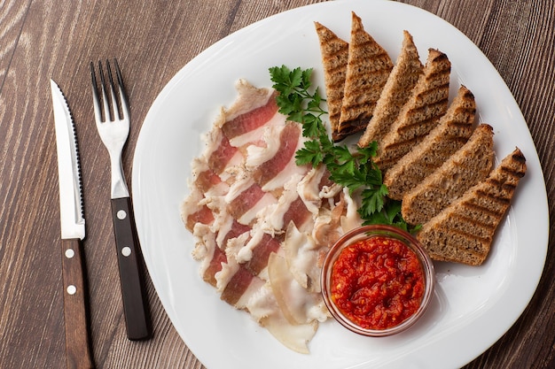 Lard de porc haché cru avec de la viande une tête d'ail et de pain de seigle sur un fond en bois pour l'espace de copie