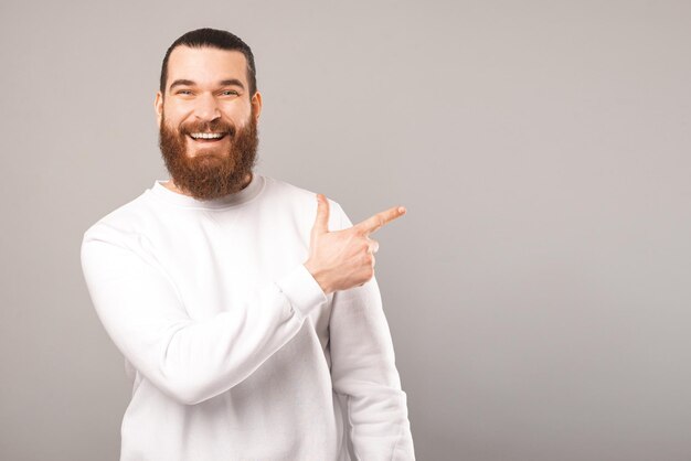 Un large homme souriant vous montre l'offre qu'il pointe du doigt