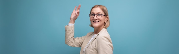 Large photo horizontale d'une femme d'affaires mûre confiante dans une veste classique sur fond clair