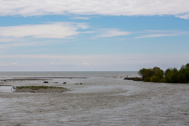 Une large rivière se jette dans la mer au printemps