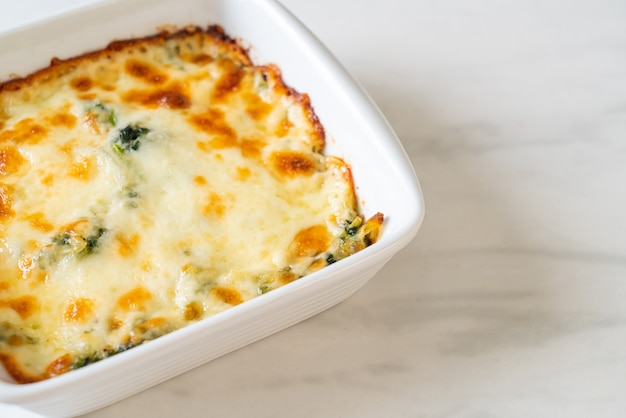 Lasagne aux épinards au four avec du fromage dans une assiette blanche