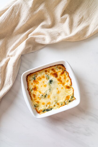 Lasagne aux épinards au four avec du fromage dans une assiette blanche