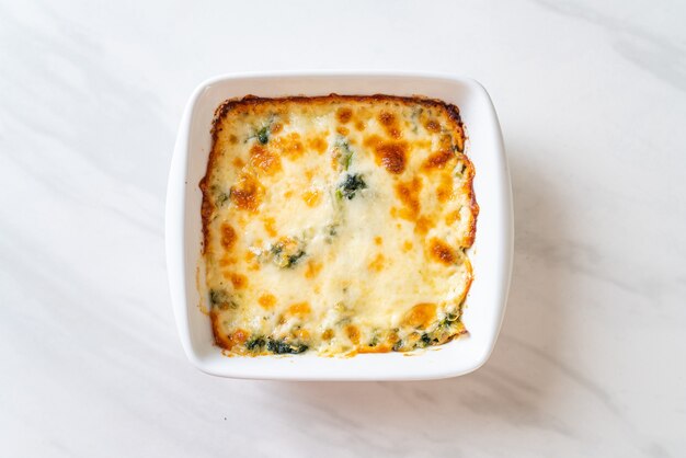 Lasagne aux épinards cuit au four avec du fromage dans une assiette blanche