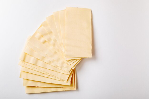 Lasagne crue Feuilles de pâte sèche pour lasagne sur fond blanc