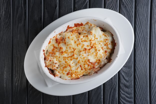 Photo lasagne cuisine italienne. vue de dessus. assiette sur un bois