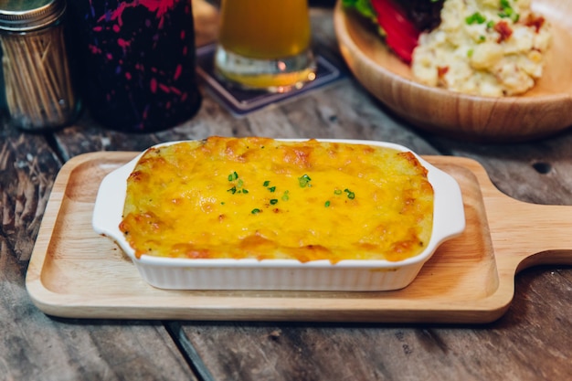 Lasagne cuite au four avec fondant au fromage servi dans une assiette en bois