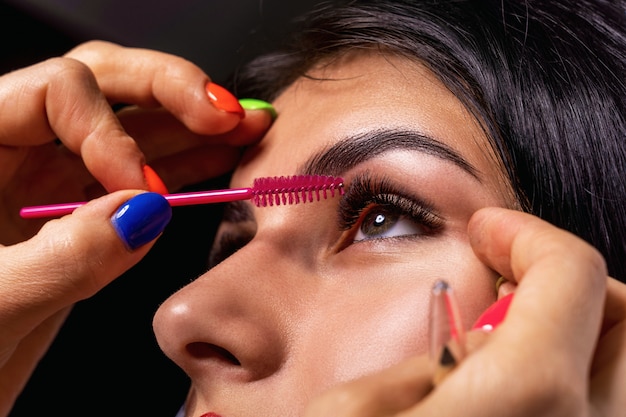 Lashmaker sépare les cils avec une brosse