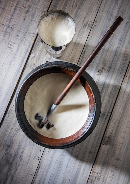 Lassi sucré indien composé de lait, caillé, sucre et sel mélangés à des glaçons, servi dans un verre en acier jumbo, préparé dans un pot traditionnel en terre