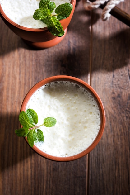 Lassie ou lassi en verre de terre cuite - Lassi est une boisson froide indienne authentique composée de lait caillé et de lait et de sucre