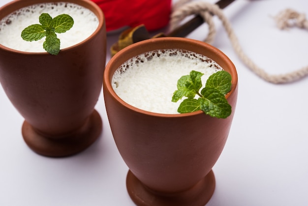 Lassie ou lassi en verre de terre cuite - Lassi est une boisson froide indienne authentique composée de lait caillé et de lait et de sucre