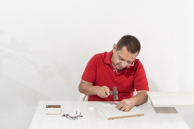 Photo un latino assemble des meubles à la maison