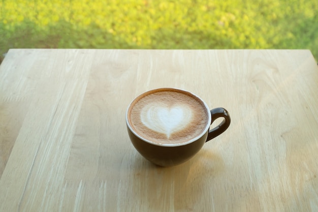 Latte art café dans la matinée avec la lumière du soleil sur le fond en bois de table.