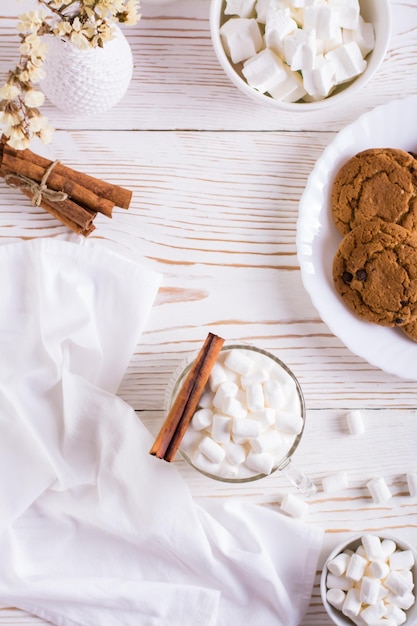 Latte au lait avec des guimauves dans une tasse et une assiette avec des biscuits faits maison Vue de dessus et verticale