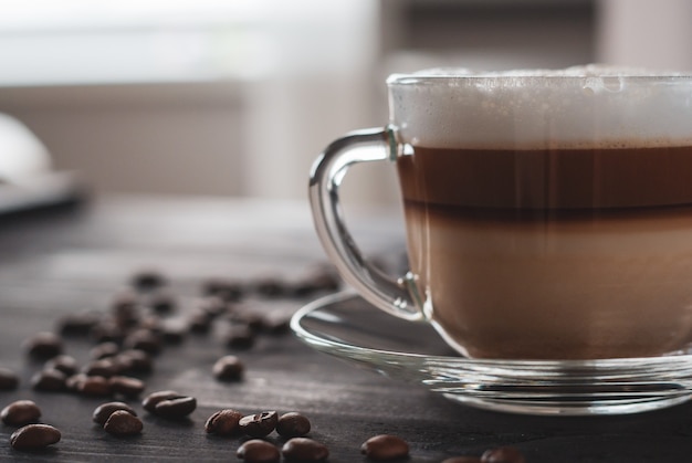 Latte chaud ou cappuccino préparé avec des couches blanches, brunes et crémeuses, surmontées d'un capuchon en mousse