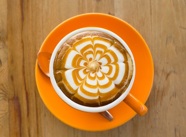 Un Latte Coffee art sur le bureau en bois.