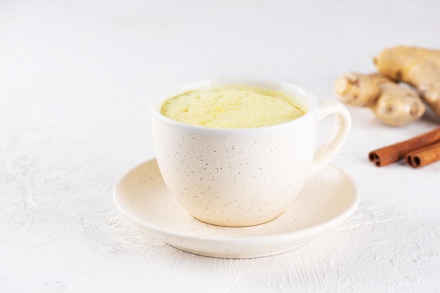 Latte de curcuma indien au lait d'amande gingembre curcuma et cannelle dans une tasse sans sucre et sans lactose