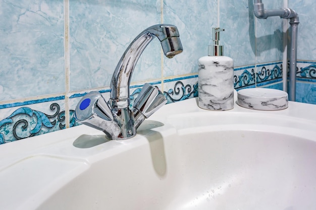 Lavabo du robinet d'eau avec robinet dans une salle de bains loft coûteuse Détail d'une cabine de douche d'angle avec fixation murale pour douche