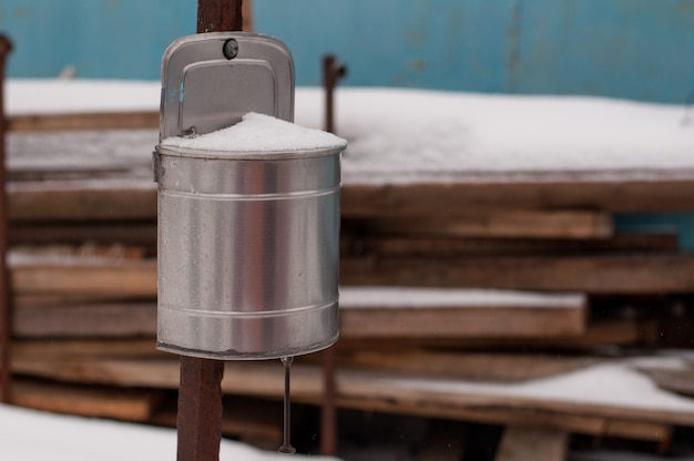 Lavabo en métal sur un poteau rouillé sur fond de planches