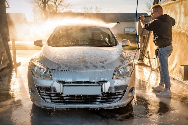 Lavage auto en libre service. L'homme lave sa voiture