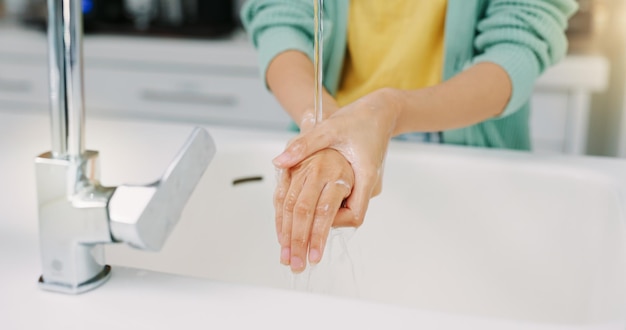 Lavage des mains femme nettoie et évier de cuisine d'une femme avec du savon pour le nettoyage et le bien-être Sécurité à domicile et protection contre les virus d'une personne avec des soins de santé dans une maison pour le soin de la peau et le toilettage
