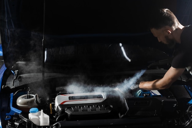 Lavage à la vapeur du moteur de l'auto en détaillant le service automatique Processus de nettoyage à la vapeur du moteur de voiture de la poussière et de la saleté