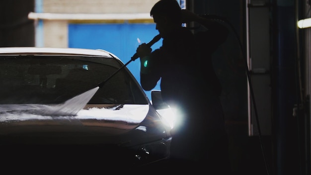 Lavage de voiture en atelier automobile - silhouette, téléobjectif