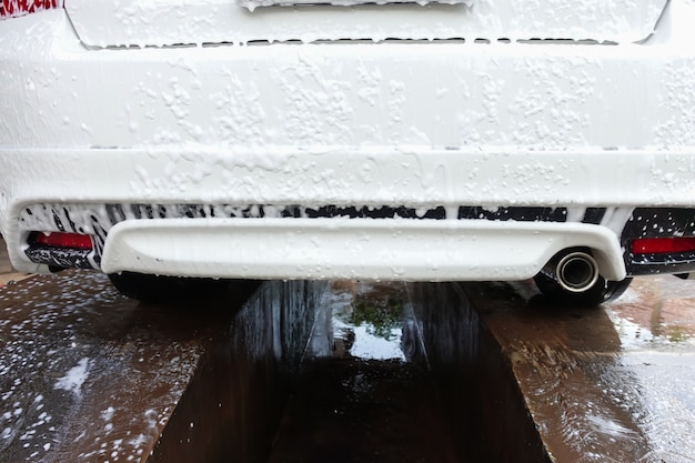 Lavage de voiture avec du savon et de la mousse dans les soins de la voiture