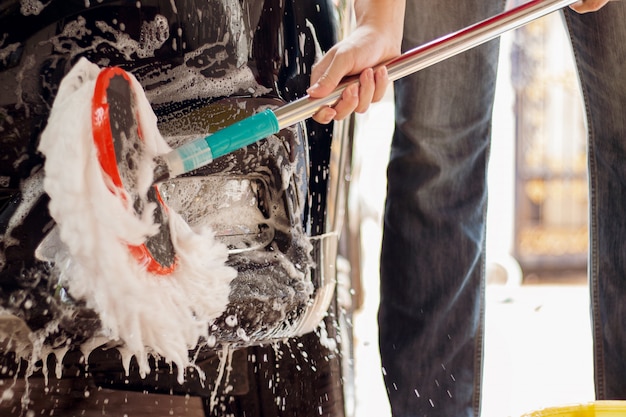 Photo lavage de voiture, nettoyage de voiture utilisation d'une éponge pour laver la voiture