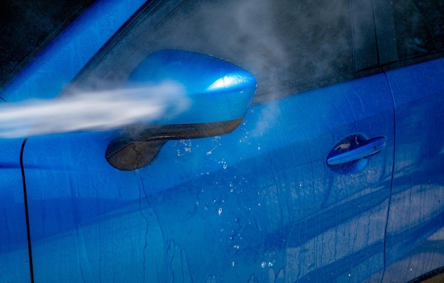 Lavage de voiture avec pulvérisation d'eau à haute pression Nettoyage de voiture Concept de service d'entretien automobile Nettoyage de véhicule