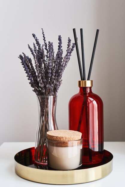 Lavande séchée dans un vase Bougie aromatique et bouteille de diffuseur de parfum sur un plateau en métal