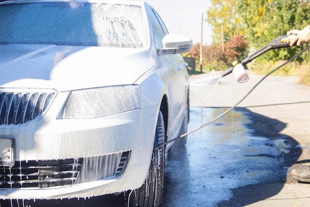 Lave-Auto. Lave-Auto. L'homme lave la voiture. Mousse