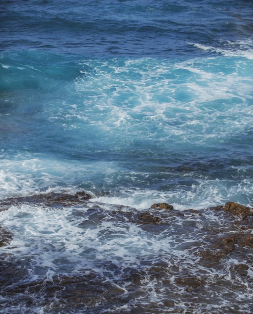Lave noire refroidie battue par les vagues de l'océan Atlantique Vue sur les vagues de la mer frappant les rochers sur la plage Vagues et rochers