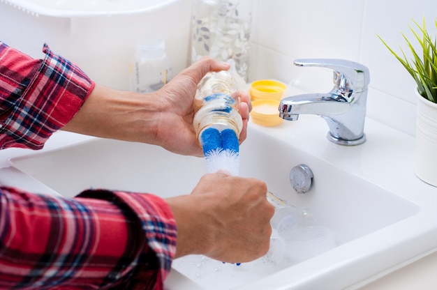 Laver les biberons et les tétines avec un goupillon souple et du liquide vaisselle