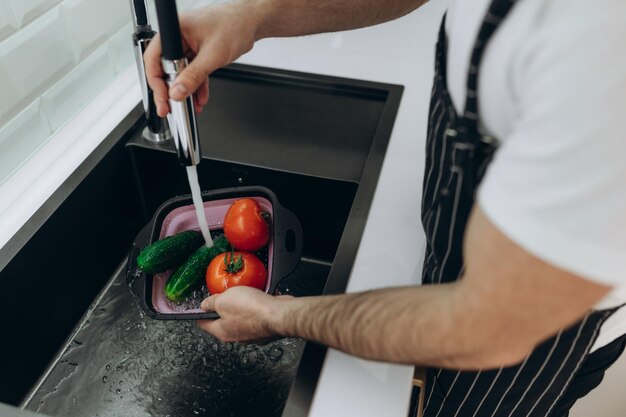 Laver les légumes dans la cuisine Concombres Tomates