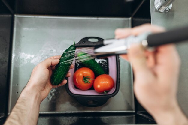 Laver les légumes dans la cuisine Concombres Tomates