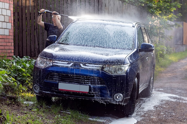 Laver la voiture avec du savon à l'aide d'un nettoyeur haute pression